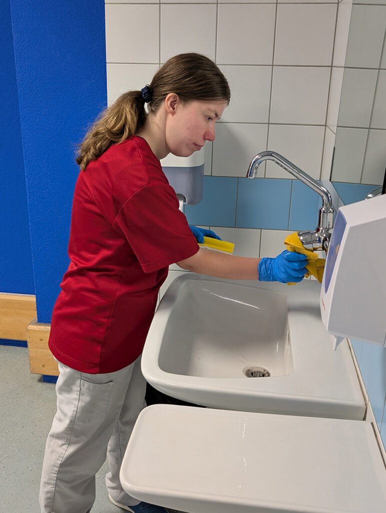 Nicole putzt ein Lavabo im iwaz